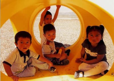 Four daycare children outside in a playground set.