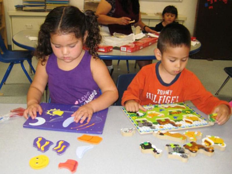 Children developing problem-solving skills through puzzles at a CCCDS center